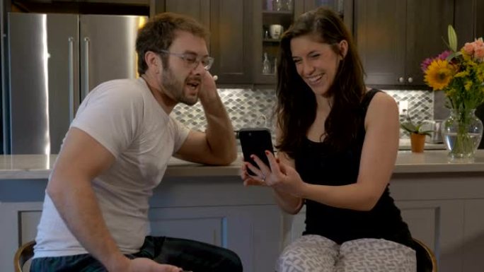 美丽的夫妇用他们的智能手机技术应用程序聊天和娱乐