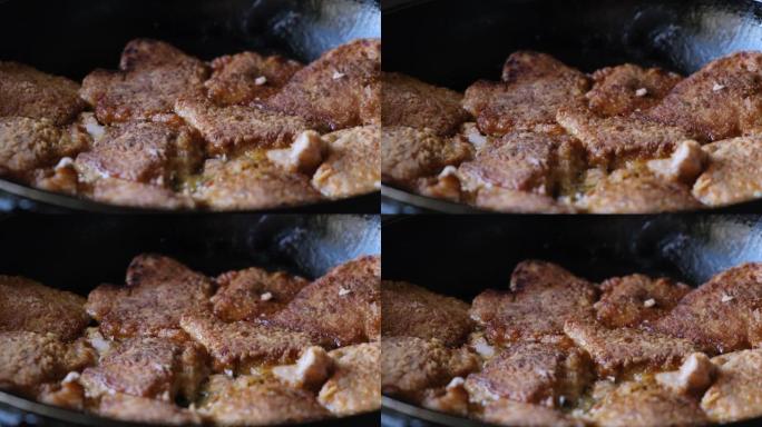 在平底锅里用油油炸的多汁新鲜猪肉块特写镜头。