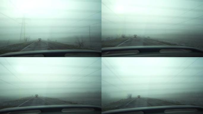 司机坐在有雾的路上。从乘客舱内部查看。