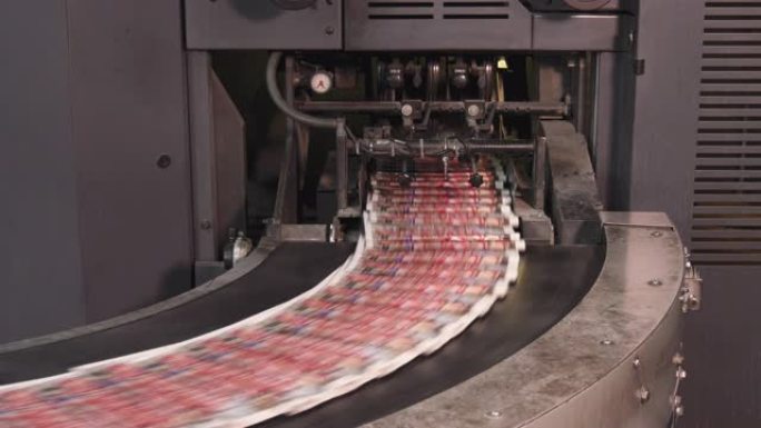 印刷厂在输送机上高速移动的印刷报纸