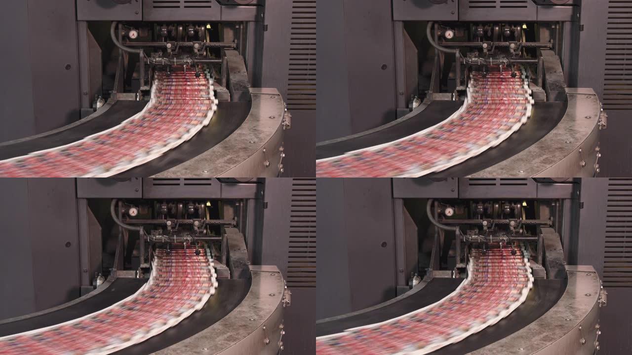 印刷厂在输送机上高速移动的印刷报纸