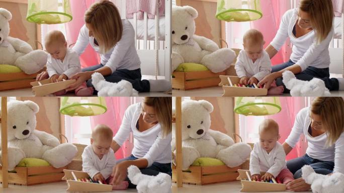 木乃伊和婴儿在托儿所地板上玩玩具