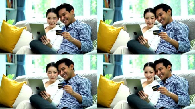微笑的女人使用数字平板电脑，而开朗的男人在网上购物时拿着Visa信用卡
