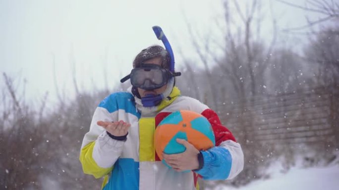 穿着带充气球的潜水面具的滑稽男子站在降雪下。迷失在时间里