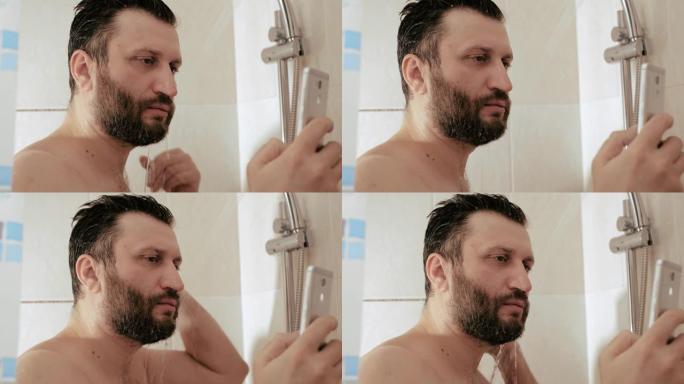 一个拿着电话洗澡的男人。一个大胡子的家伙在电话上阅读新闻时在水下洗头。互联网社交网络智能手机细胞成瘾