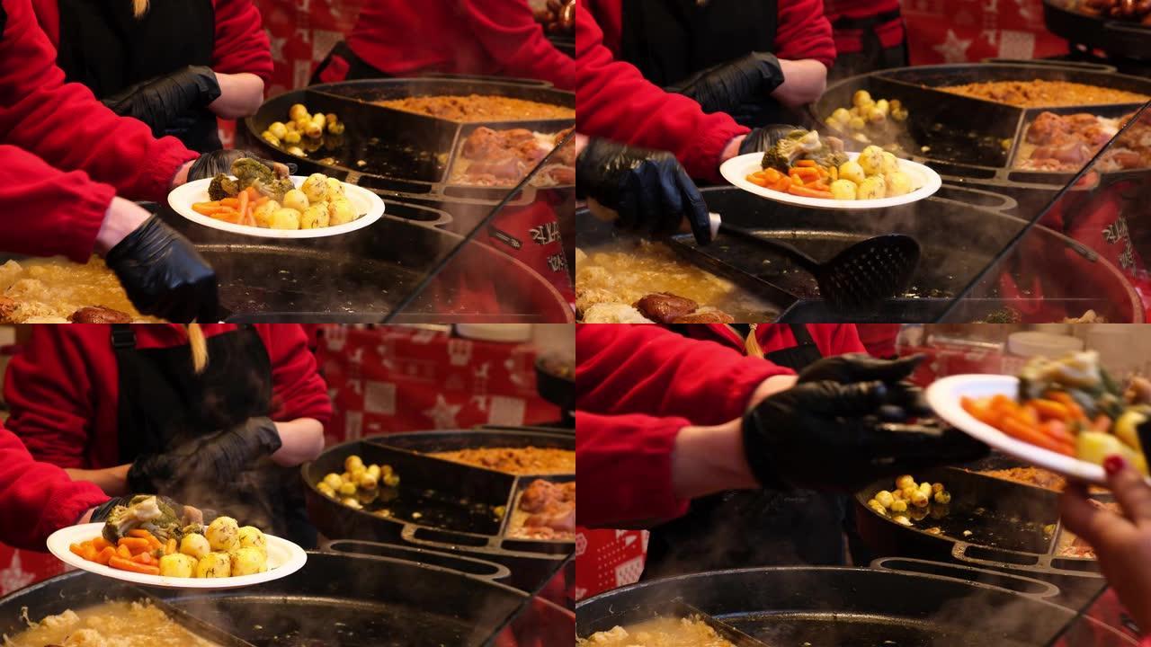 供应商在户外咖啡馆的盘子上出售新鲜的炸肉和土豆。在博览会上招待饥饿的游客