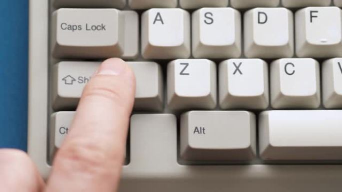 男性手指按下白色键盘上的SHIFT按钮。慢动作和宏观视图