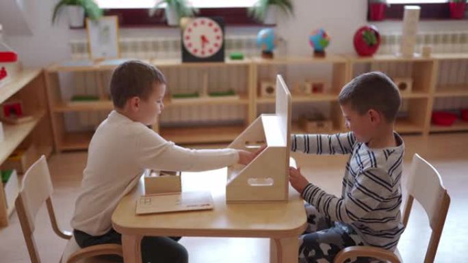 两个男孩在学龄前教室里一起玩耍