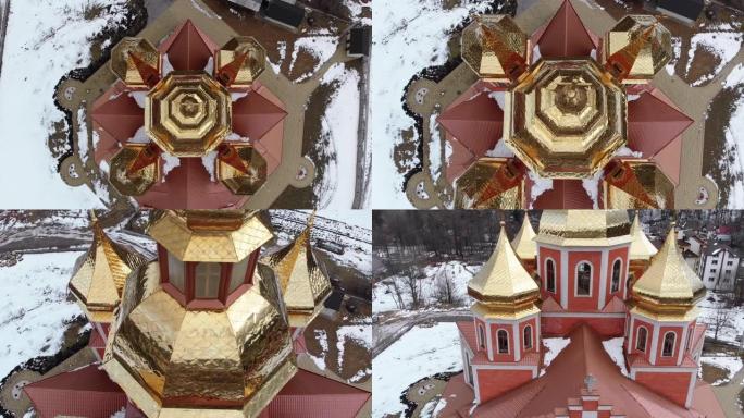 冬季喀尔巴阡山村带有金色圆顶的乌克兰教堂的空中俯视图