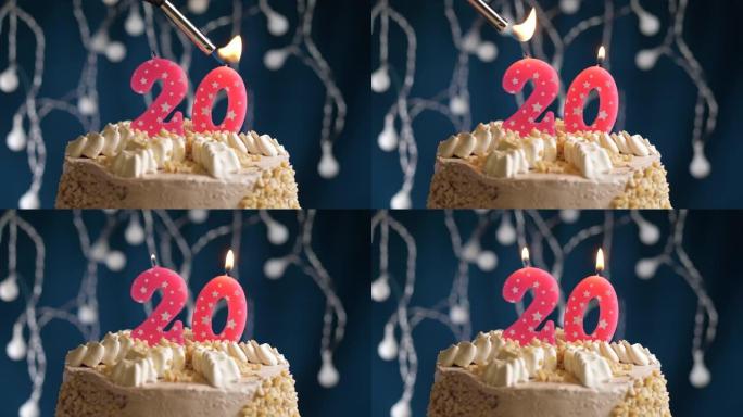 蓝色背景上有20号粉色蜡烛的生日蛋糕。蜡烛着火了。慢动作和特写视图