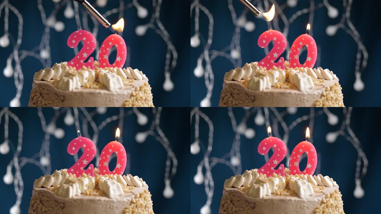 蓝色背景上有20号粉色蜡烛的生日蛋糕。蜡烛着火了。慢动作和特写视图