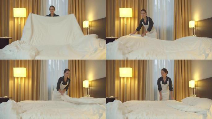 穿着制服的女佣在旅馆房间里铺床铺毯子