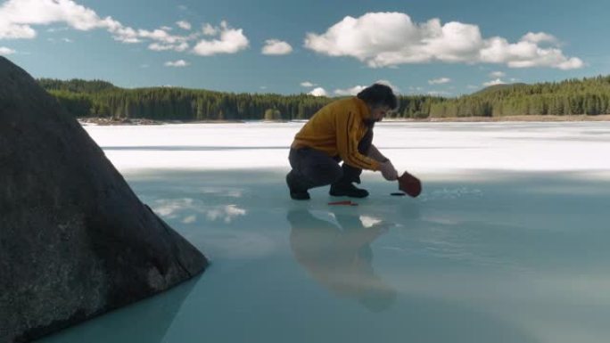 打破僵局。一个英俊的男人站在冰冻的湖面上。