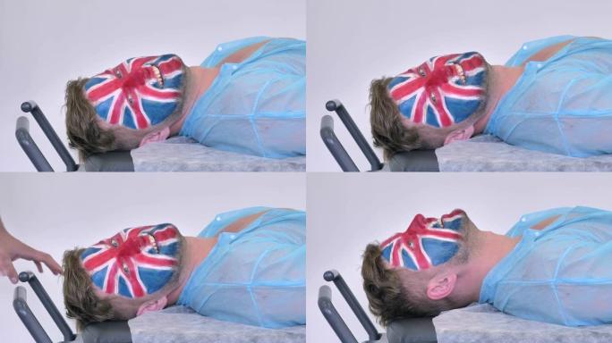 特写，侧视图，英国人的肖像 (足球迷，英格兰国旗/英国国旗画在他的脸上) 在医院的病床上看着相机。希