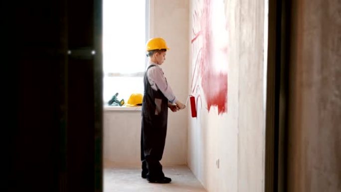 修复草稿公寓-疲倦的小男孩用红色油漆在墙上画线条