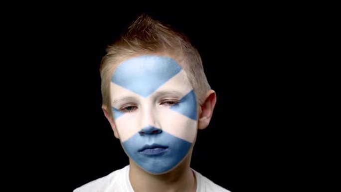 苏格兰足球队的伤心球迷。脸上涂着民族色彩的孩子。