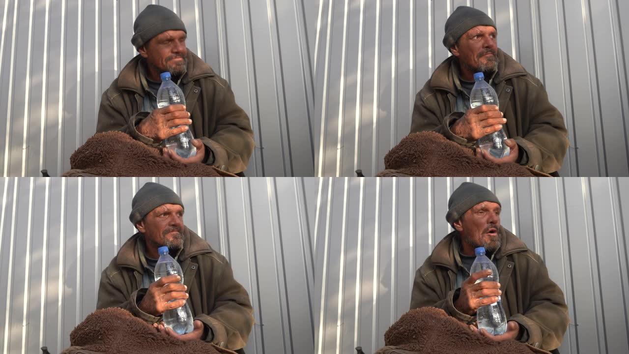无家可归的人拿着一瓶塑料水。