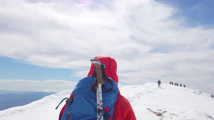冬季，女性高山登山者与她的团队一起在高海拔的山峰上移动。