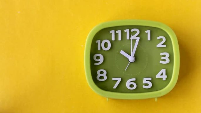 绿色时钟，白色数字和箭头隔离在黄色背景上，实时