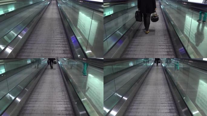 人们在机场的活动传送带上经过。人们赶往航班，在国际机场航站楼的人行道上行走自动扶梯