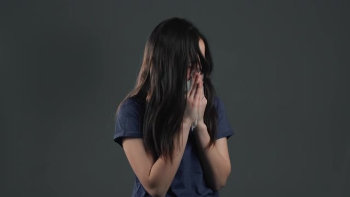 年轻的亚洲女孩打喷嚏成组织。灰色工作室背景上的孤立女性生病，有感冒或过敏反应。冠状病毒，流行病202
