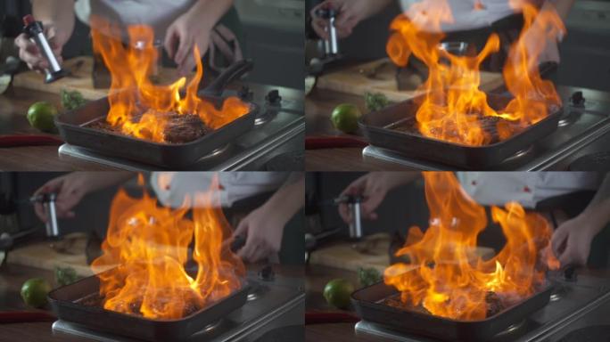 厨师在烤盘上制作flambe风格的牛排菲力牛排。用明火点燃石油和酒精。美食。美食厨房里的营养。做饭。