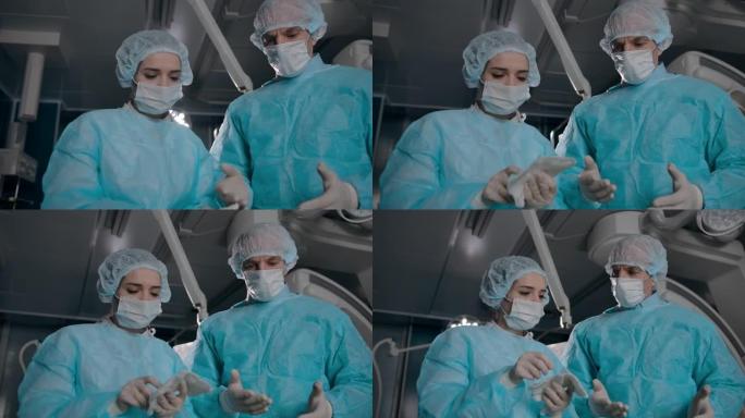 两名穿着长袍的外科医生为手术准备设备