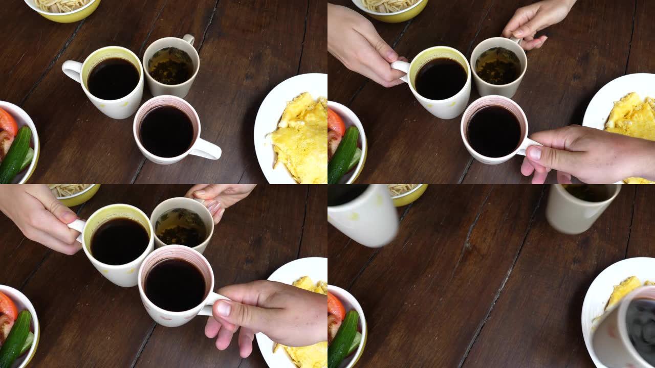 三个朋友在早餐时用热饮碰杯