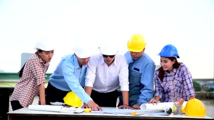 建造师团队安全服信任团队在施工现场手持白色黄色安全安全帽安全设备。土建工程师概念的安全帽保护头部