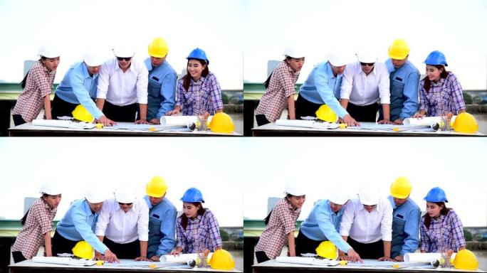建造师团队安全服信任团队在施工现场手持白色黄色安全安全帽安全设备。土建工程师概念的安全帽保护头部