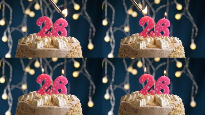 蓝色背景上有26个粉色蜡烛的生日蛋糕。蜡烛着火了。慢动作和特写视图