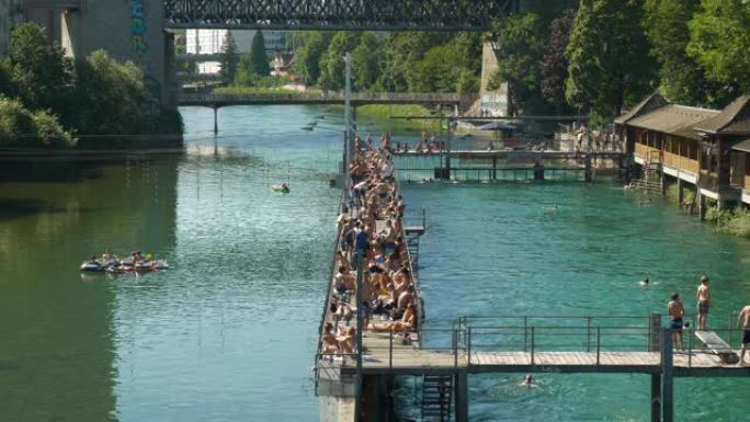 阳光明媚的苏黎世市中心著名的拥挤河滩湾浴慢动作全景4k瑞士