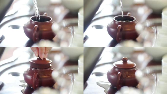 手从茶壶里倒热水。