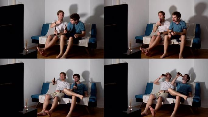 两个男性朋友在电视上观看体育比赛时喝啤酒
