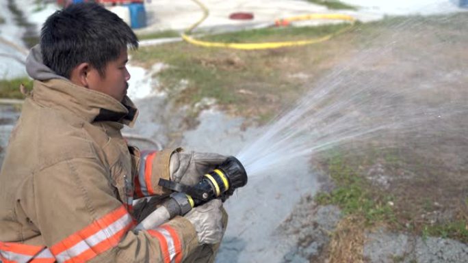 消防人员灭火，用高压喷嘴喷水，用烟雾包围