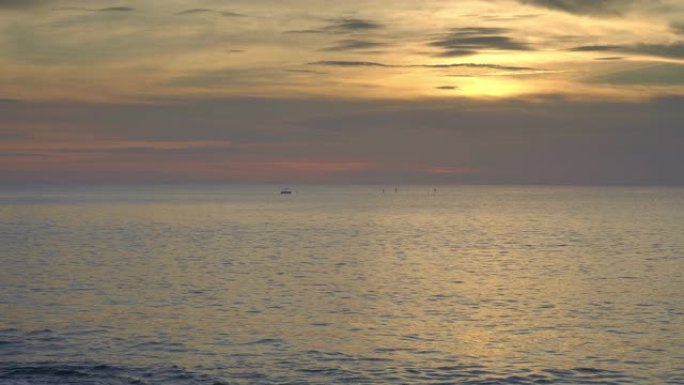 日落海洋海滩美丽的海浪和划船的人