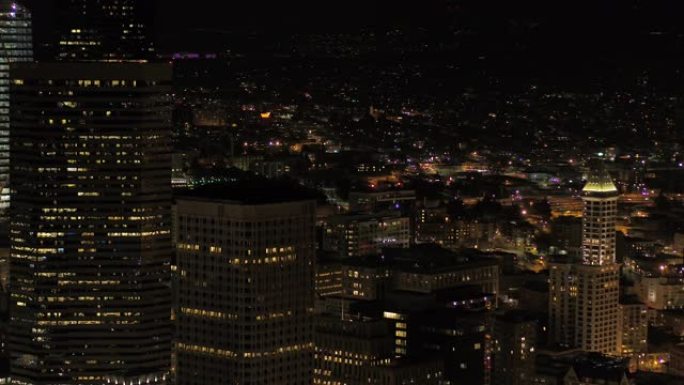 西雅图航空v114特写镜头在夜间在市中心低空显示，城市景观