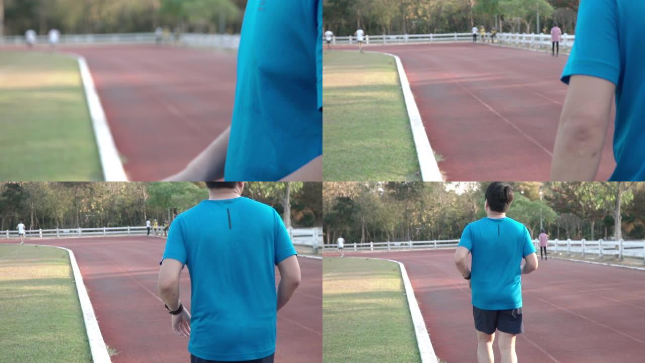 亚洲男子跑步前使用智能手表。