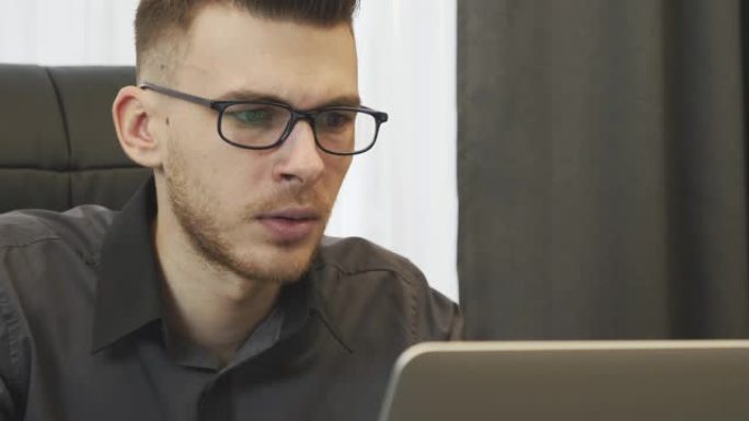 对互联网上看到的新闻感到震惊的人的特写。戴着眼镜的商人在笔记本电脑屏幕上阅读公司的不良评论。男性看着