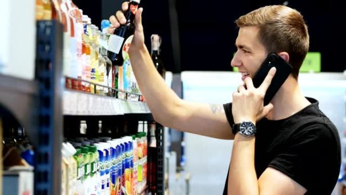 快乐男人在超市里选择产品，在手机上聊天，顾客在商店的货架上选择商品