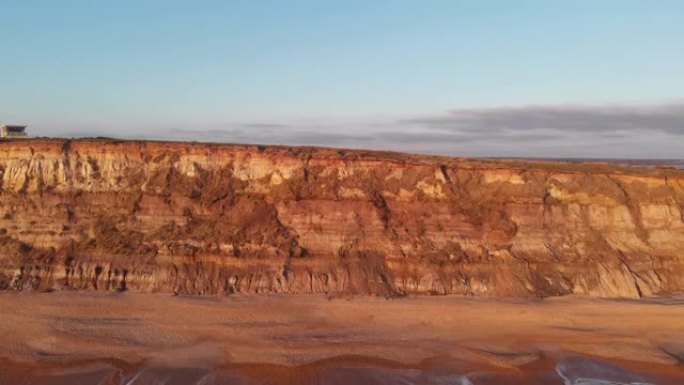 空中侧面 (从右到左) 显示了Hengistbury Head悬崖的镜头，其中包括救生员站，美丽的沙