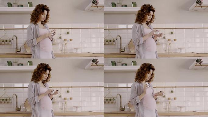 pregnant woman taking prenatal vitamins in kitchen