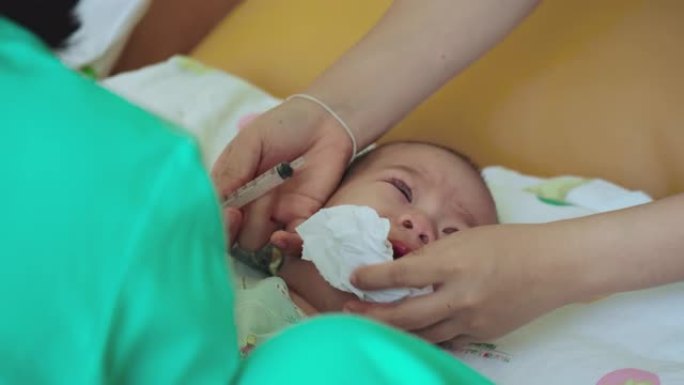 护士用注射器给孩子婴儿生病的药。