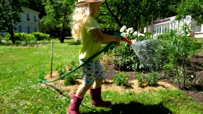戴着帽子的金发园丁孩子拿着喷水器和喷花。万向节