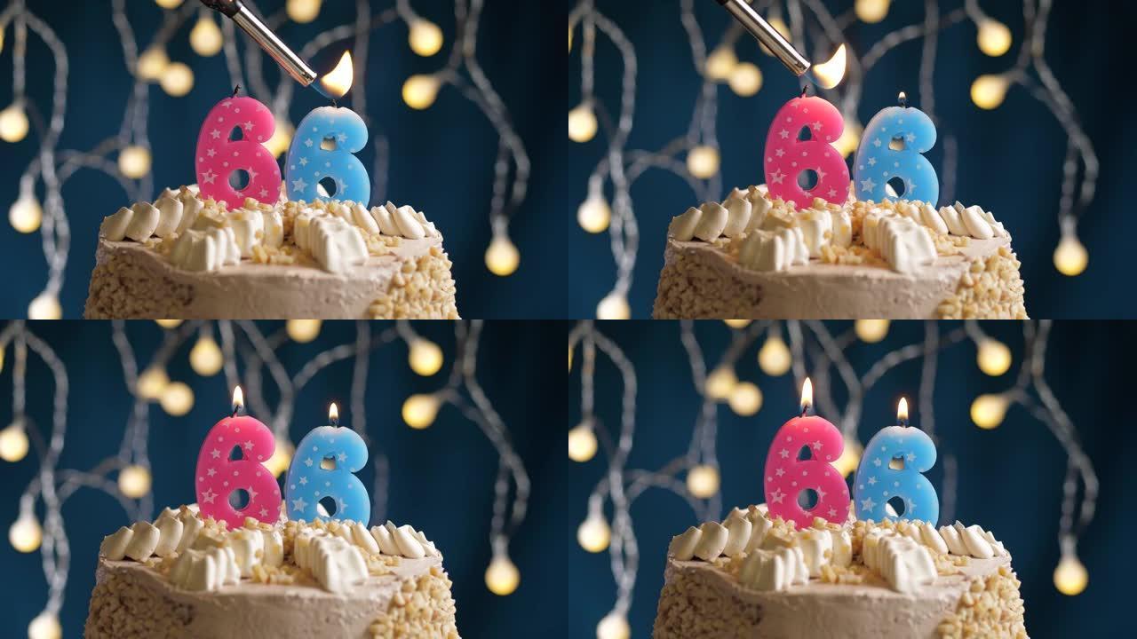 蓝色背景上有66号粉色蜡烛的生日蛋糕。蜡烛着火了。慢动作和特写视图