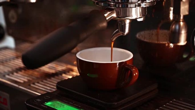 从咖啡机倒出的浓缩咖啡的特写镜头。专业咖啡酿造。