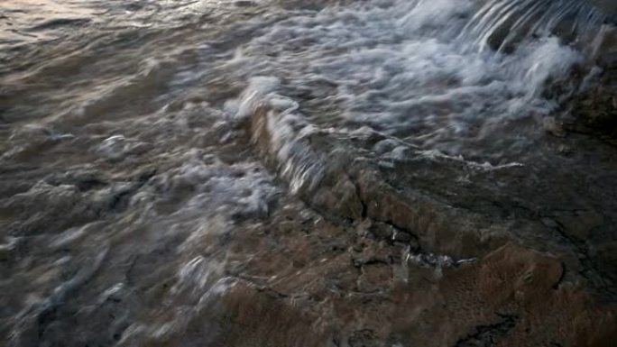 Water flowing into limestone travertines of pamukk