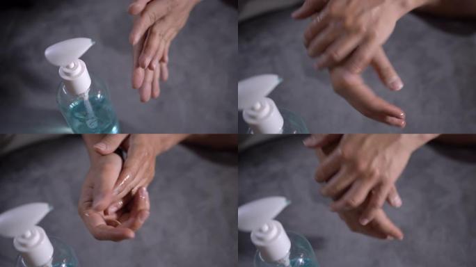 4k亚洲男子擦手使用灰色背景消毒剂凝胶，自检疫，蓝色酒精凝胶，疾病预防，手部清洁，敲击透明塑料泵瓶，