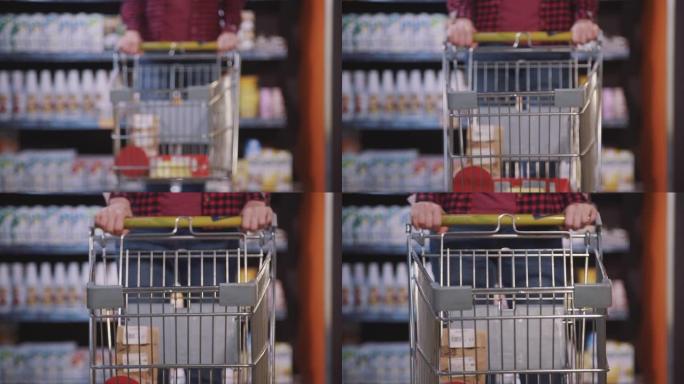 美国妇女的特写镜头，手推车在超市内部行走