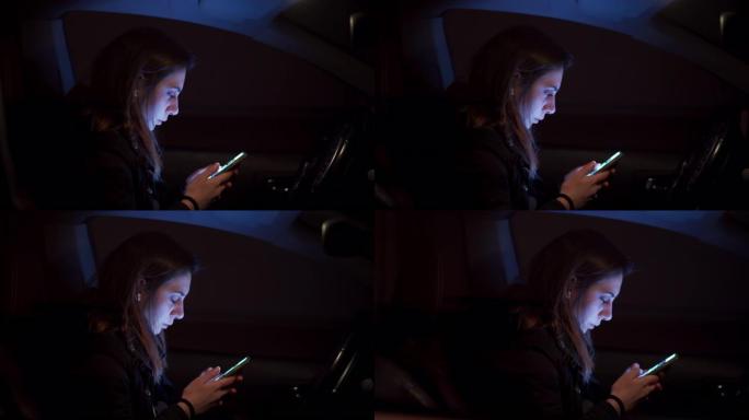 十几岁的女孩使用电话，坐在黑暗中的汽车里